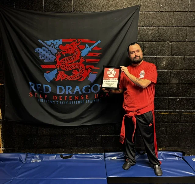 Albert Enriquez holding the 2026 Main Street award at the dojo